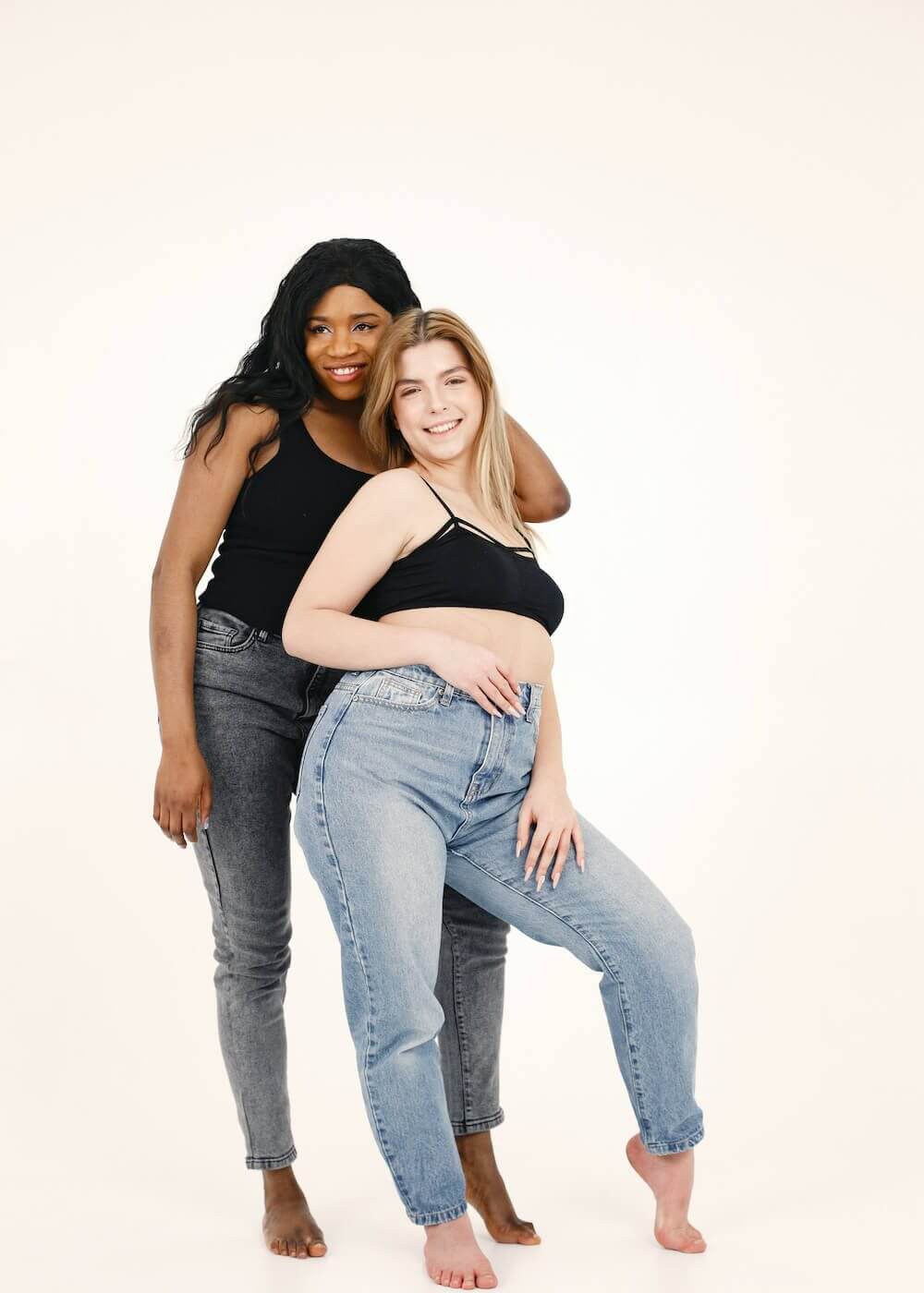 PCOS Sisters Two women in jeans posing for a photo.