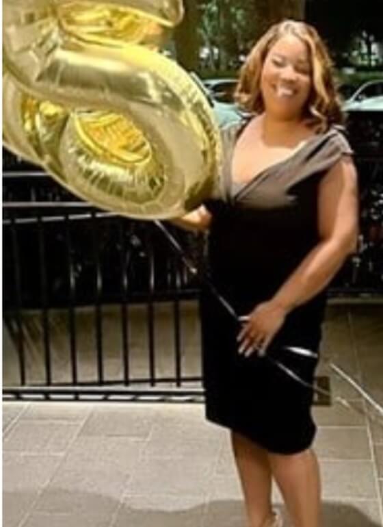 PCOS Sisters A woman in a black dress holding a gold balloon before her Weight Loss Journey PCOS.